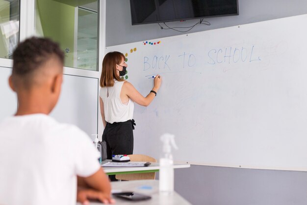 Lehrer schreibt etwas auf das Whiteboard mit Kopierraum