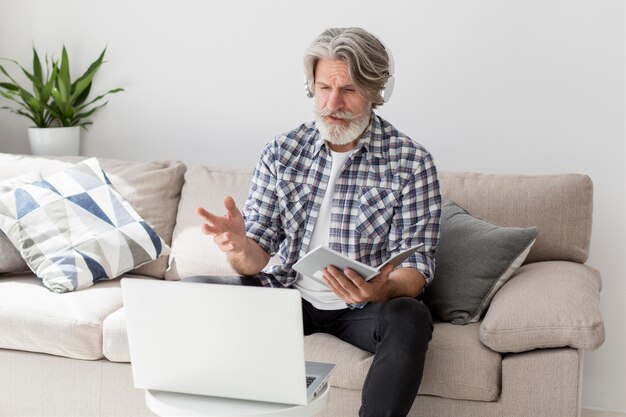 Lehrer spricht am Laptop, der Notizbuch hält