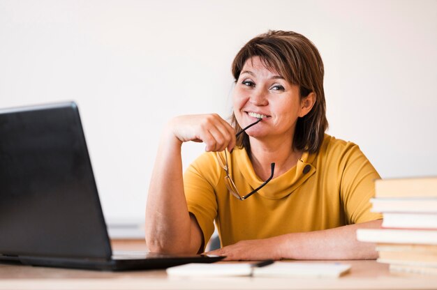 Lehrerin mit Laptop, der am Schreibtisch sitzt