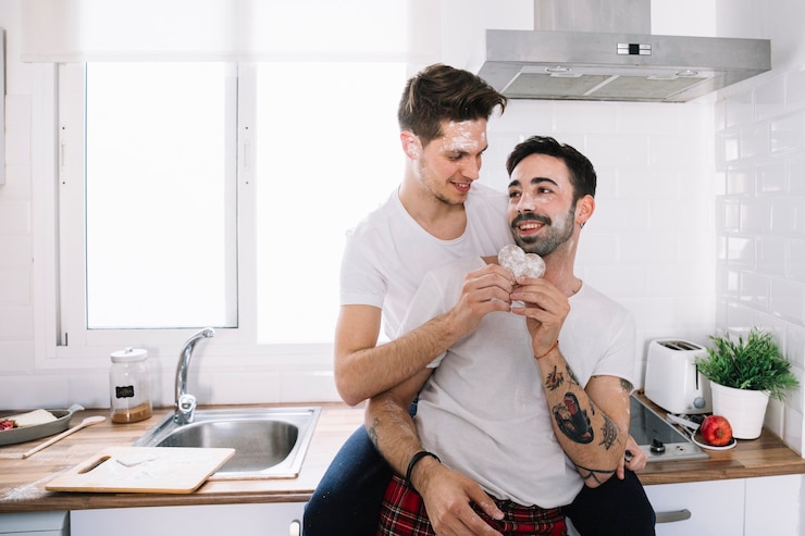Kostenlose Foto leichte liebevolle männer mit plätzchen in der küche