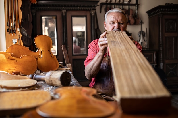 Kostenloses Foto leitender schreinerhandwerker, der holzqualitätsqualität vor der arbeit prüft