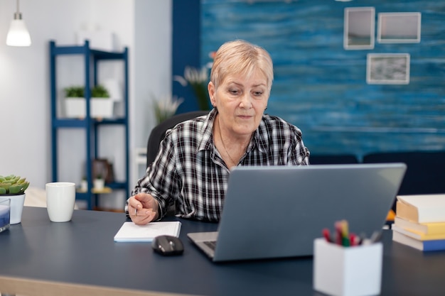 Leitender unternehmer, der ohne brille von einem tragbaren computer liest