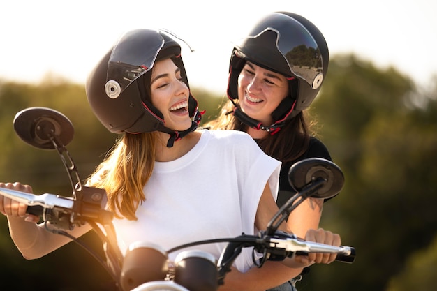 Lesbisches Paar auf einem Motorrad mit Helmen