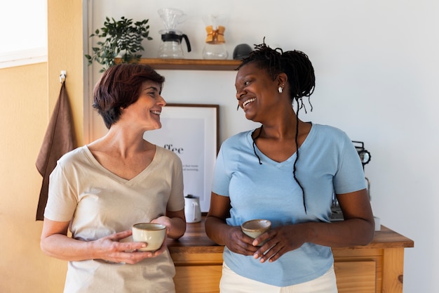 Kostenloses Foto lesbisches paar der vorderansicht mit kaffeetassen