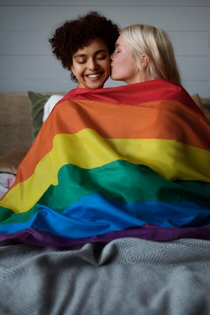 Lesbisches Paar küsst sich mit LGBT-Flagge
