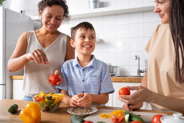 Lesbisches Paar mit Sohn bereitet Essen zu