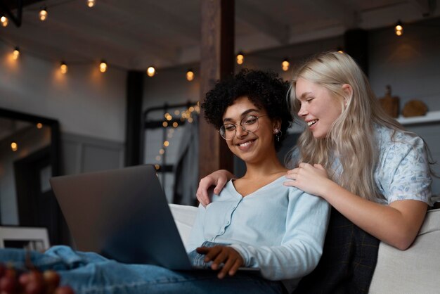 Lesbisches Paar schaut auf seinen Laptop