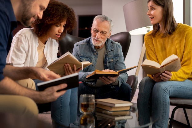 Kostenloses Foto leute aus dem niedrigen winkel, die über bücher sprechen