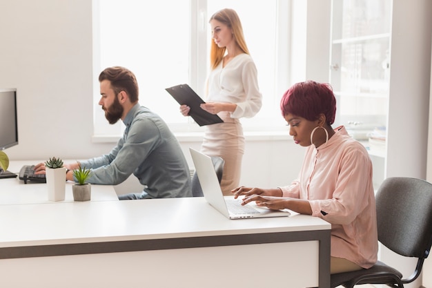 Kostenloses Foto leute, die an projekt im hellen büro arbeiten