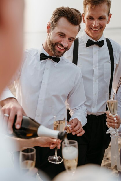Leute, die bei einer Strandhochzeit etwas trinken