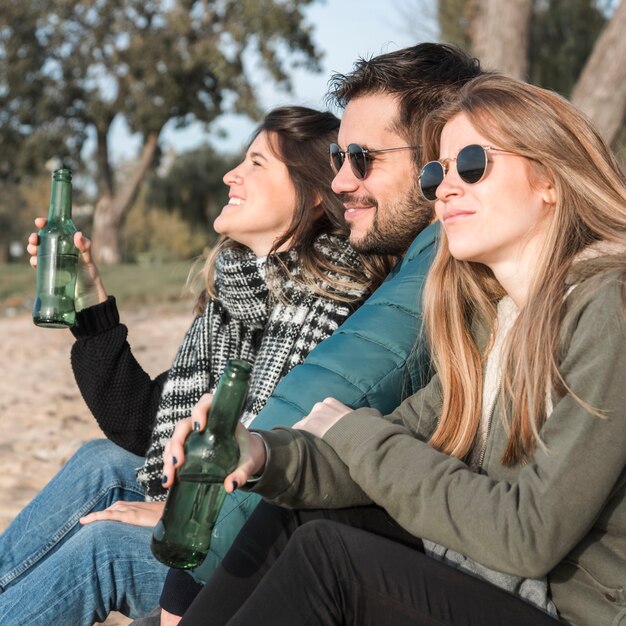 Leute, die Bier auf Naturhintergrund trinken