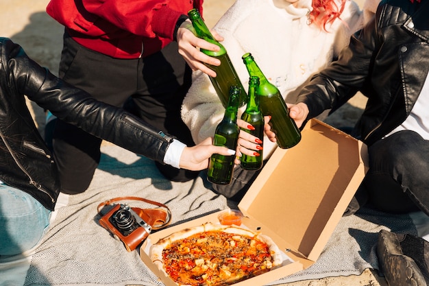 Leute, die Bierflaschen auf Picknick klirren