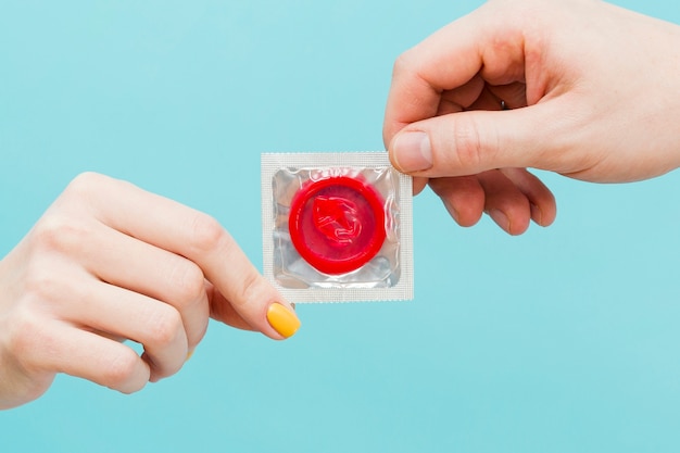 Leute, die ein rotes Kondom halten