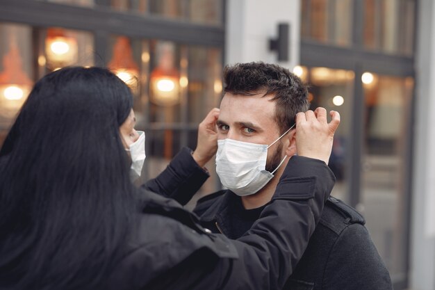 Leute, die eine Schutzmaske tragen, die auf der Straße steht