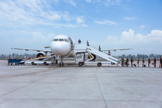 Leute, die Flugzeug auf Landebahn einsteigen