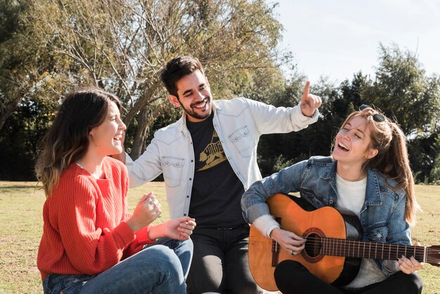 Leute, die Gitarre im Park spielen