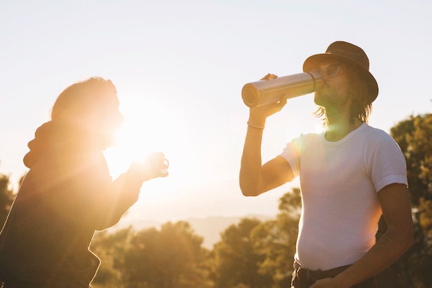 Leute, die in Landschaft trinken