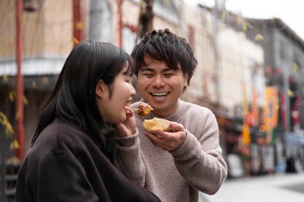Leute, die japanisches Straßenessen genießen