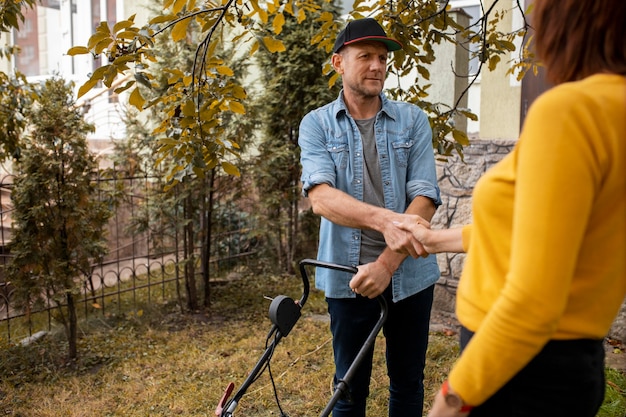 Kostenloses Foto leute, die nachbarn mit rasen helfen