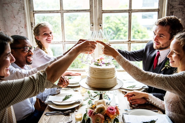 Kostenlose Foto leute, die wein-gläser auf hochzeitsempfang mit braut und bräutigam klammern