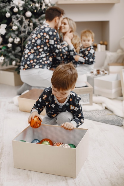 Leute, die zu Weihnachten reparieren. Leute, die mit Kind spielen. Die Familie ruht sich in einem festlichen Raum aus.