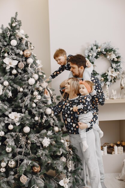 Leute, die zu Weihnachten reparieren. Leute, die mit Kind spielen. Die Familie ruht sich in einem festlichen Raum aus.