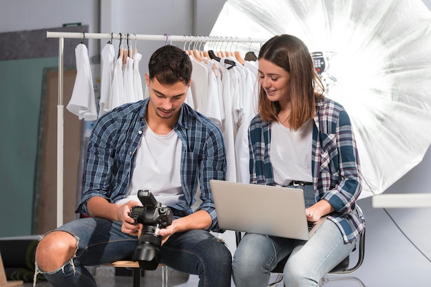 Leute, die zusammen einige Fotos aus dem Fotoshooting auswählen