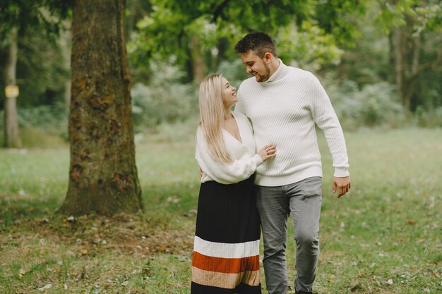 Leute in einem Park. Frau in einem weißen Pullover.