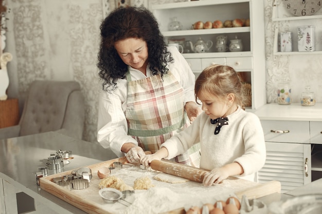 Leute in einer Küche. Großmutter mit kleiner Tochter. Erwachsene Frau lehren kleines Mädchen zu kochen.