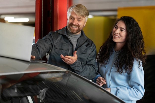 Leute mit mittlerer Aufnahme, die auf das Auto schauen