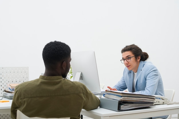 Kostenloses Foto leute mit mittlerer aufnahme, die bei der arbeit chatten