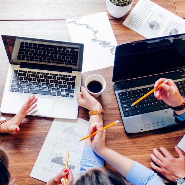 Leute sitzen am Schreibtisch mit Laptops arbeiten