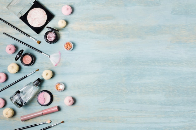 Lidschattenpinsel und Kosmetik neben Süßigkeiten