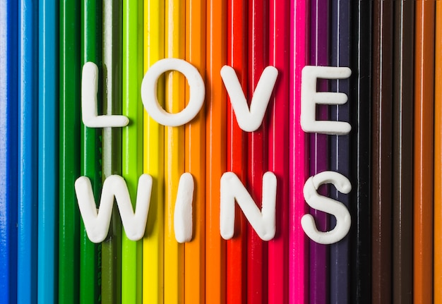 Liebe gewinnt Wörter und LGBT-Flagge von Bleistiften