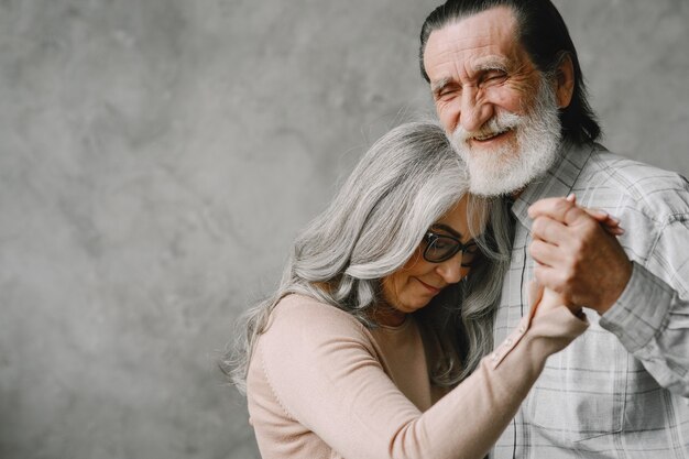 Liebe wird nie alt. Fröhliches aktives altes romantisches Paar im Ruhestand, das im Wohnzimmer tanzt.