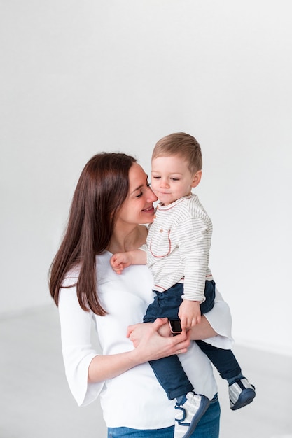 Liebende Mutter, die Kind mit Kopienraum hält