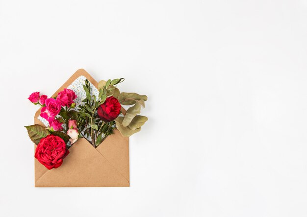 Liebes- oder Valentinstagskonzept. Rote schöne Rosen im Umschlag