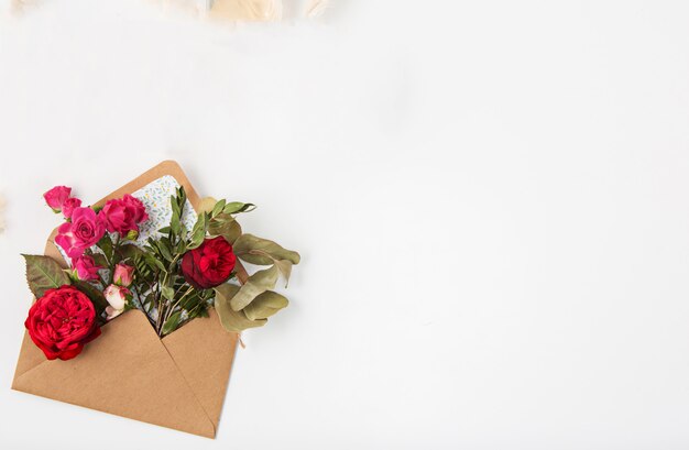 Liebes- oder Valentinstagskonzept. Rote schöne Rosen im Umschlag
