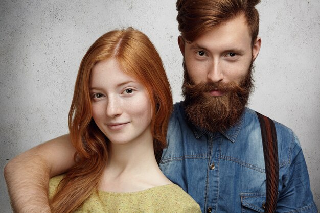 Liebes- und Freundschaftskonzept. Junges schönes und glückliches kaukasisches Paar, das umarmt, während es drinnen eine gute Zeit zusammen hat.