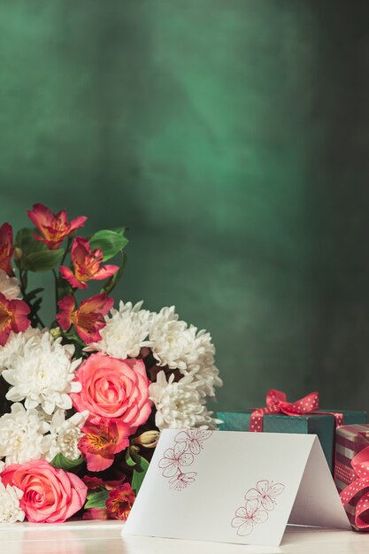 Liebeshintergrund mit rosa Rosen, Blumen, Geschenk auf Tisch