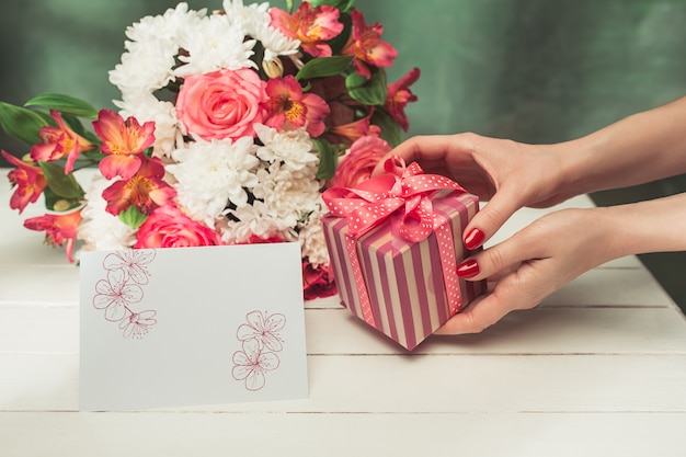Kostenloses Foto liebeshintergrund mit rosa rosen, blumen, geschenk auf tisch