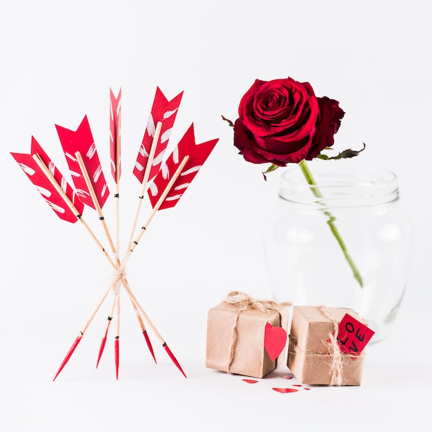 Liebespfeile mit Geschenkboxen und Rotrose