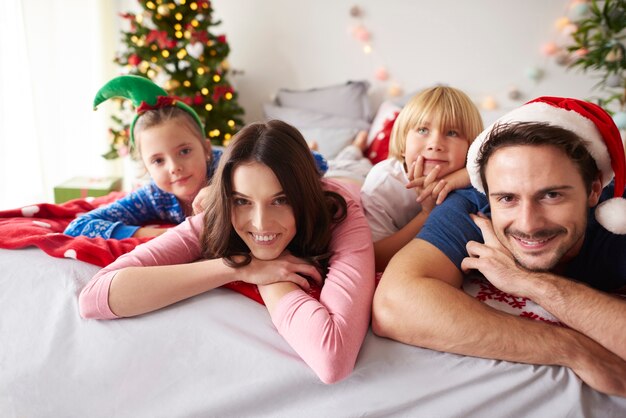 Liebevolle Familie, die Weihnachten im Bett verbringt