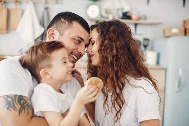 Liebevolle Familie, die zu Hause in einer Küche sitzt