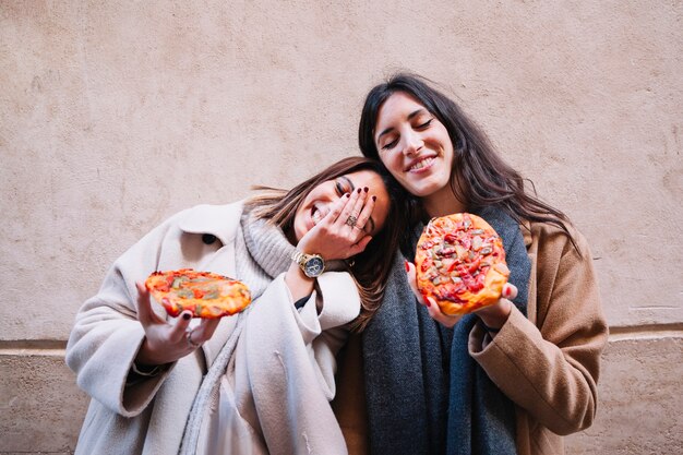 Liebevolle Freundinnen, die Pizzas haben