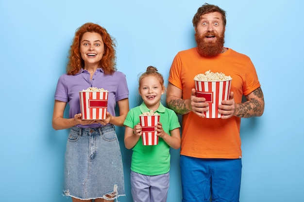 Liebevolle Ingwerfamilie, die mit Popcorn aufwirft