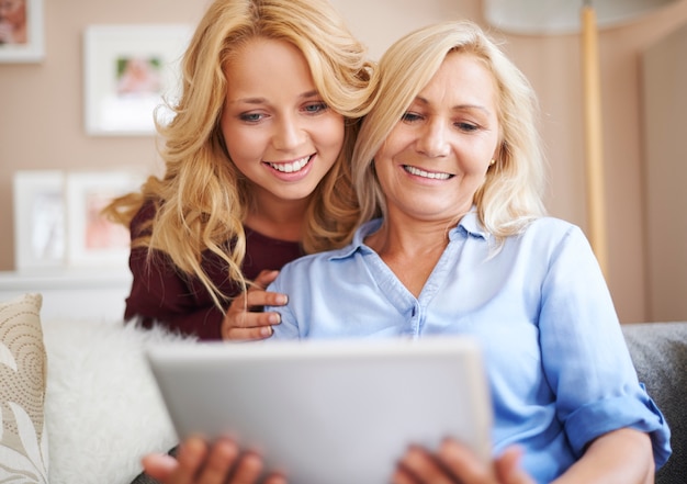 Liebevolle Mutter und Tochter genießen drahtloses Internet