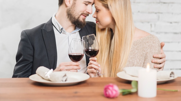 Liebevolle Paare, die auf Abendessen sich genießen
