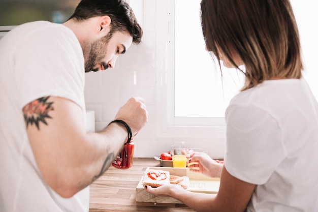 Liebevolle Paare, die zusammen Toast vorbereiten