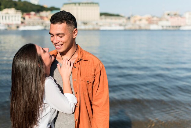 Liebevolles Paar, das Zeit zusammen am Strand mit Kopierraum verbringt